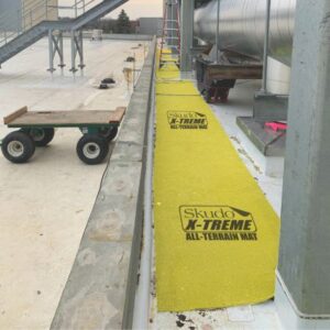 yellow mat rolled out over grey industrial roofing around large HVAC units and access points