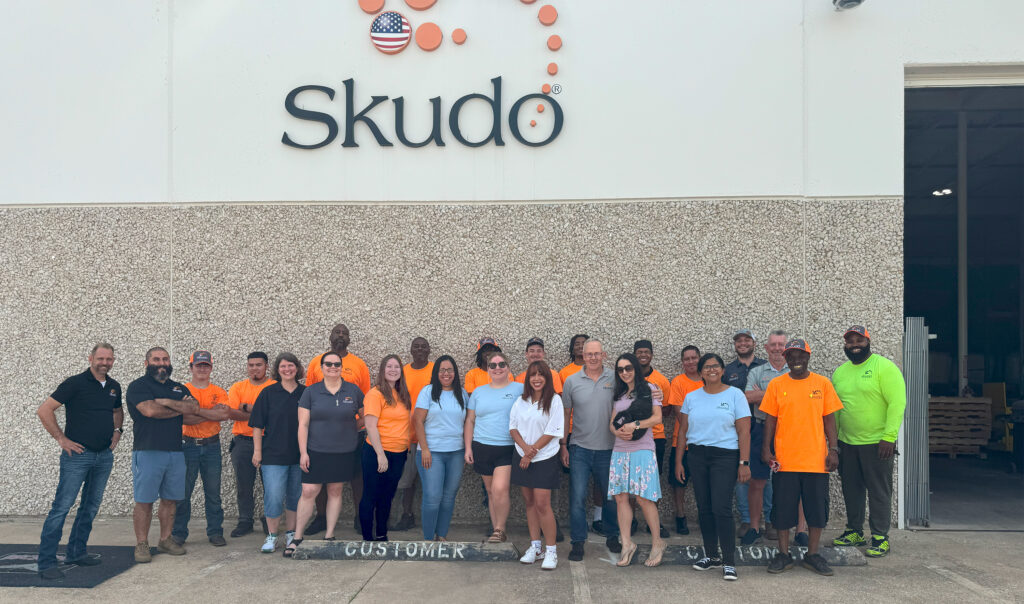 A group of employees in front of a warehouse building