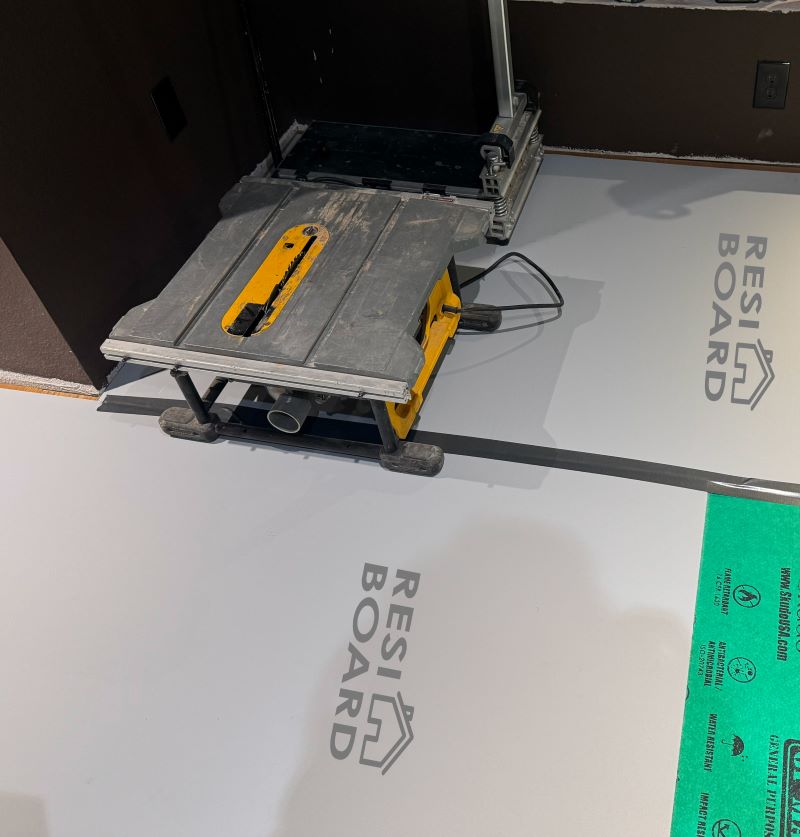 a grey floor protection board protecting a residential floor from construction materials