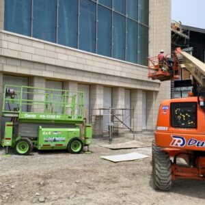building exterior under construction with forklifts and construction vehicles outside