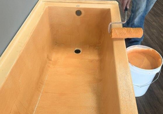 Protective Skudo USA tub coating being carefully applied to a bathtub during construction finishing phase